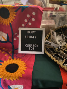 A small sign welcomes customers, reading "Happy Friday. Corazon 805" in front of the taqueria's weekly pop-up tent.