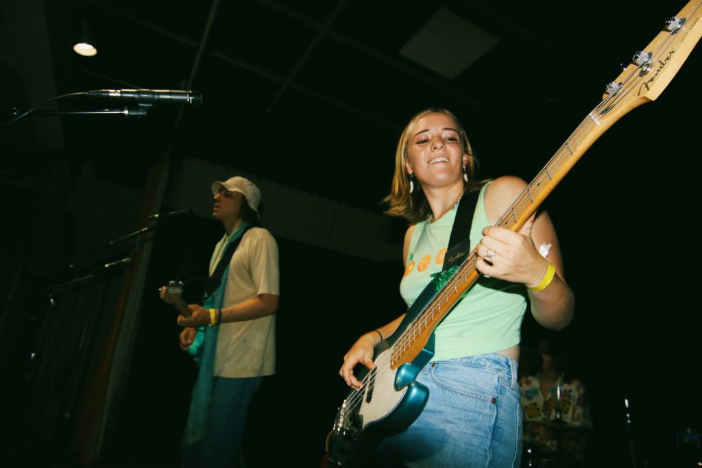 Abby Neal plays bass alongside her bandmate.