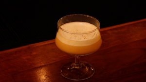 A short, stemmed glass with a cocktail sits on Highwater's bar.